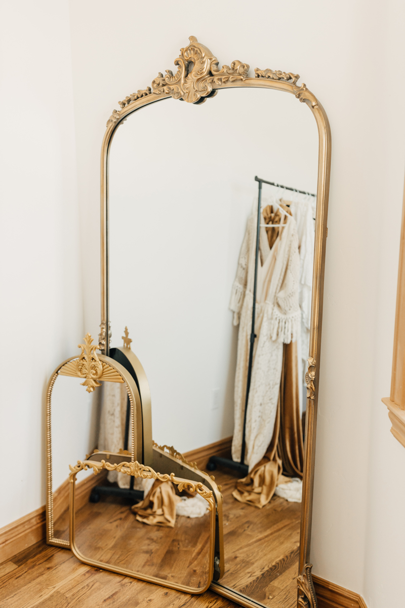 Photography Studio on Main, in the corner of a room are three mirrors with golden frames