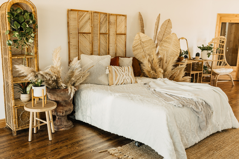 Photography Studio on Main, a boho style room is decorated with pampas grass and wicker furniture surrounding a cozy bed