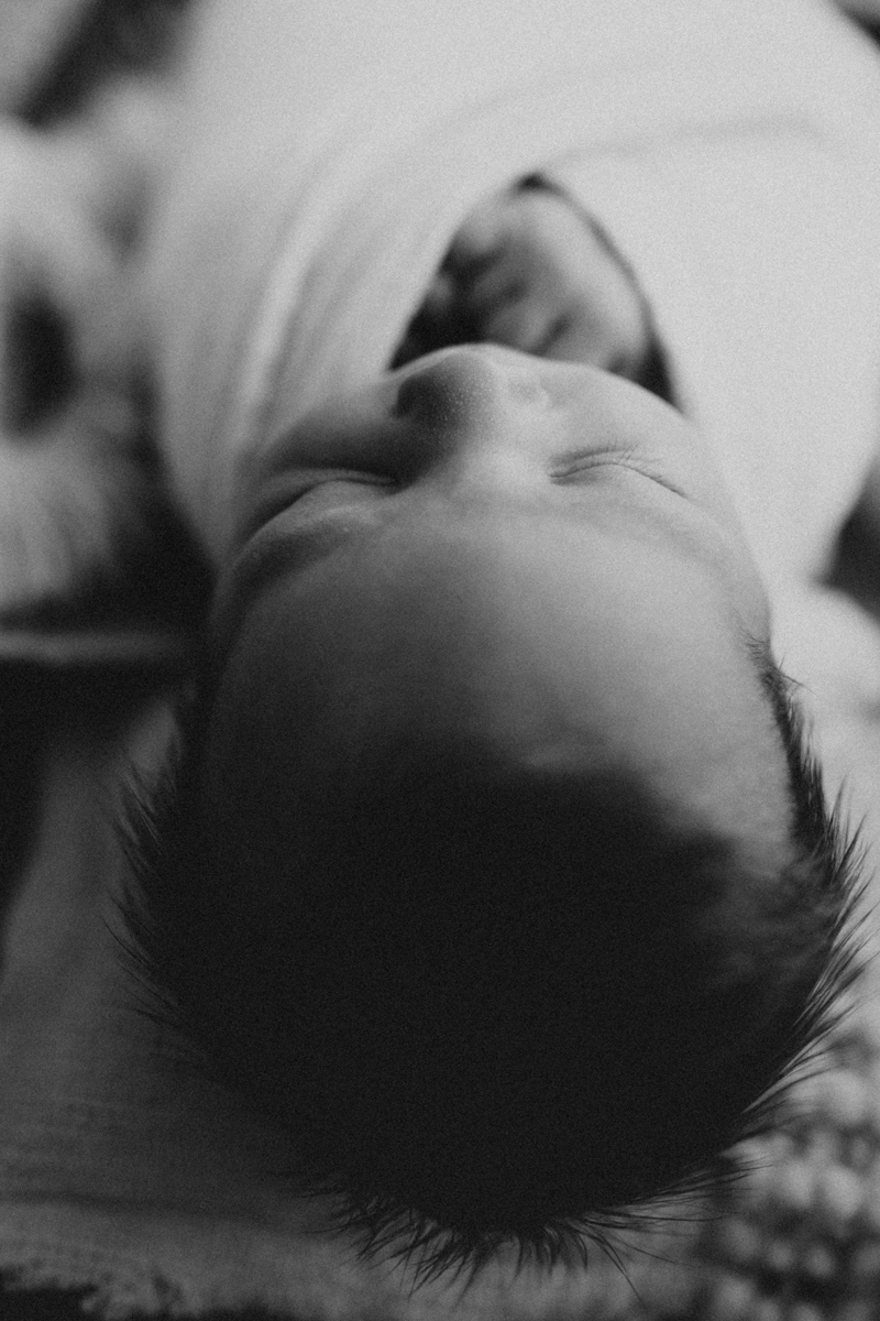 Newborn Photography, a baby lays sleeping cozily on blankets