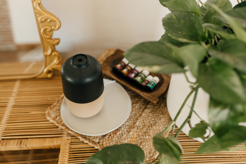 Photography Studio on Main, a wicker table holds a diffuser, essential oils and a plant